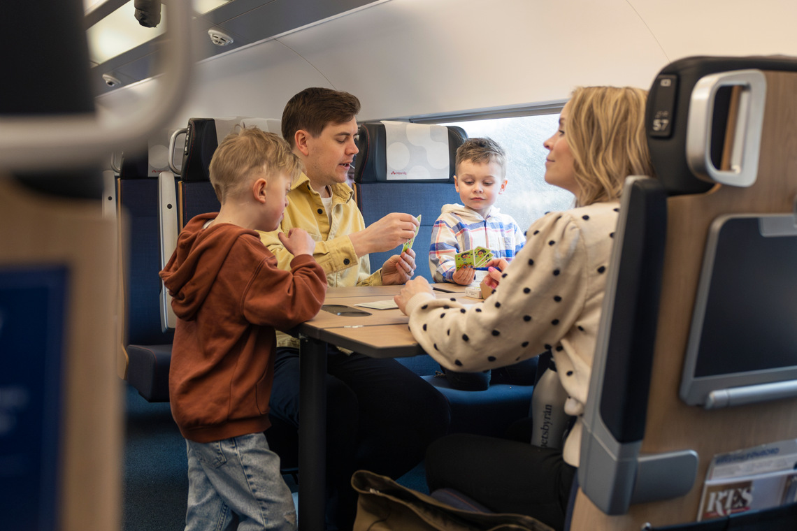 Famlj spelar kort på tåget