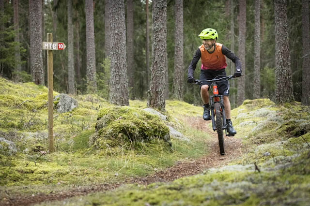 person cyklar i skogen på en mountainbike