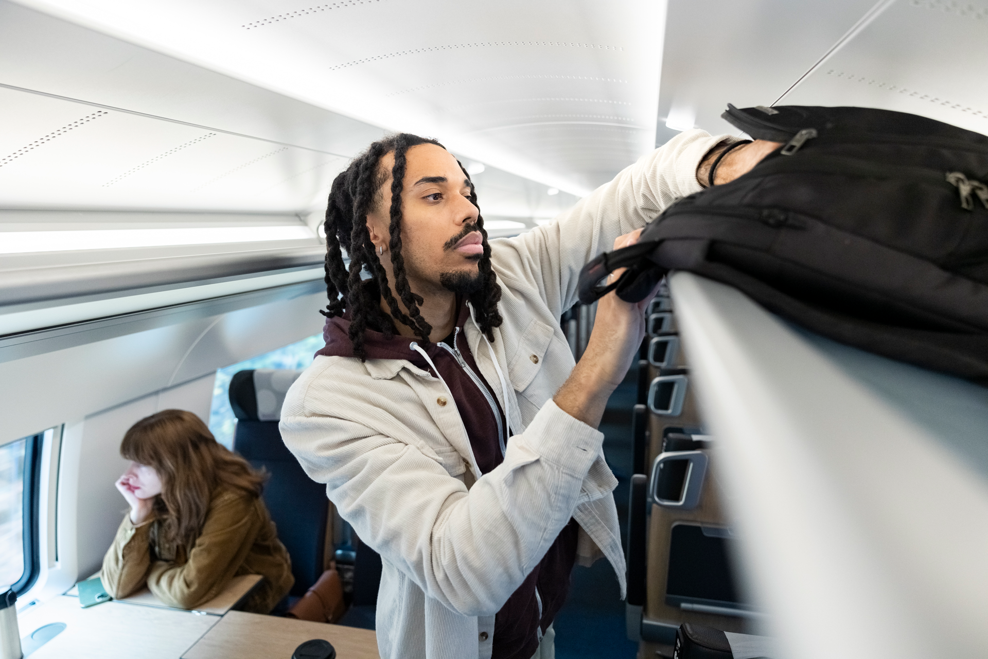 En man med packar väskan på ett tåg