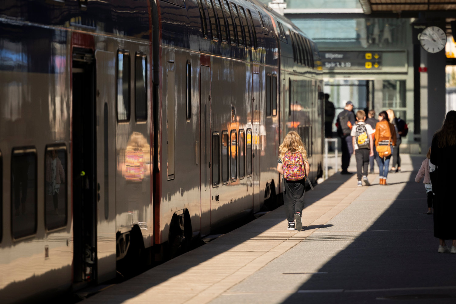 A boy walking along a mälartåg train