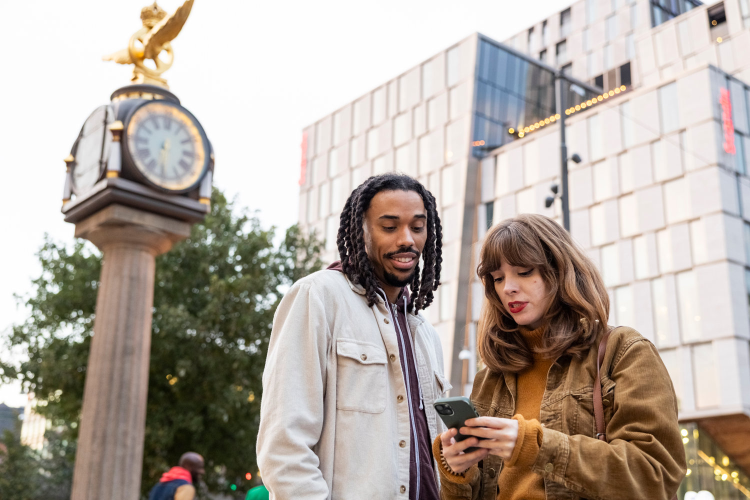Ung man och kvinna som kollar på en mobiltelefon tillsammans